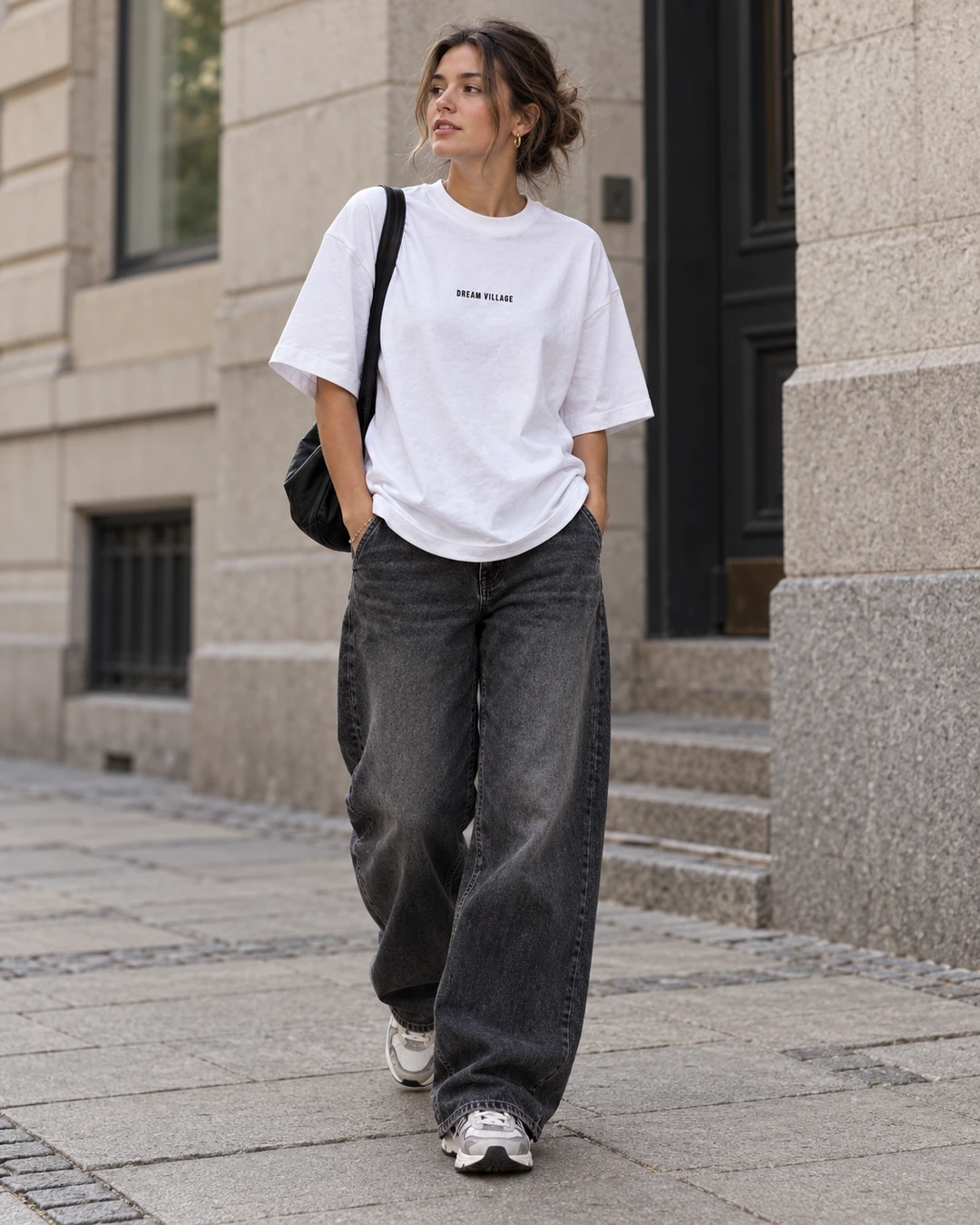 Woman wearing the white Dream Village T-shirt, front view